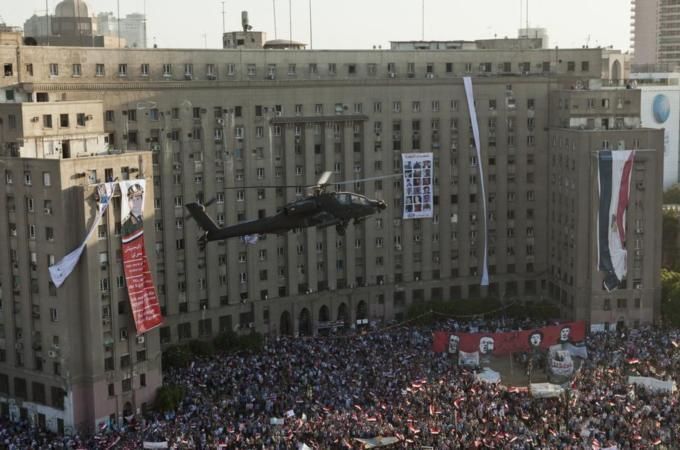 An Apache helicopter flies over Tahrir Square, Cairo, during pro-military protests last year. (Photo: Getty images)