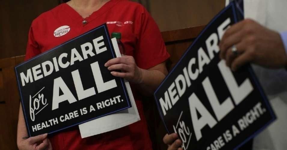 Medicare for All supporters hold signs