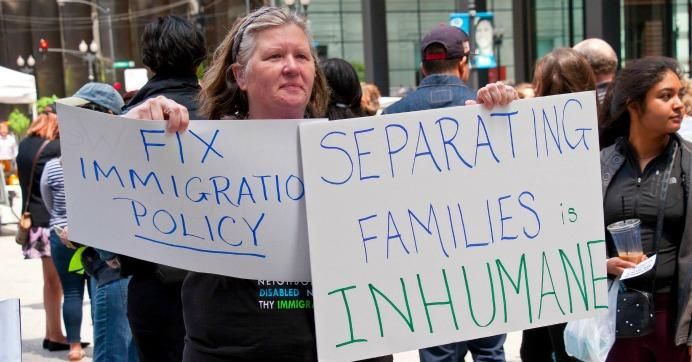 A woman holds a sign reading 'Fix immigration policy."