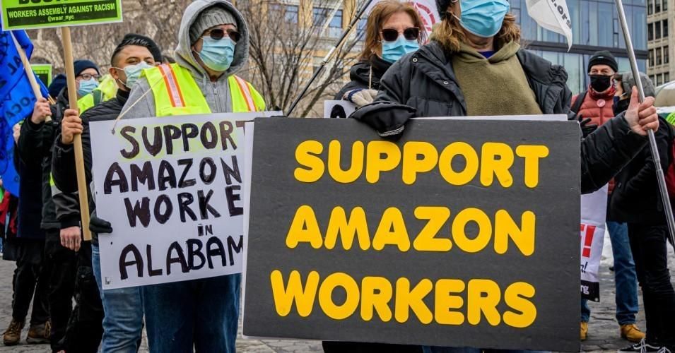 Participants seen holding signs and marching on a picket line during a solidarity event in Manhattan showing support for Amazon workers in Bessemer, Alabama.