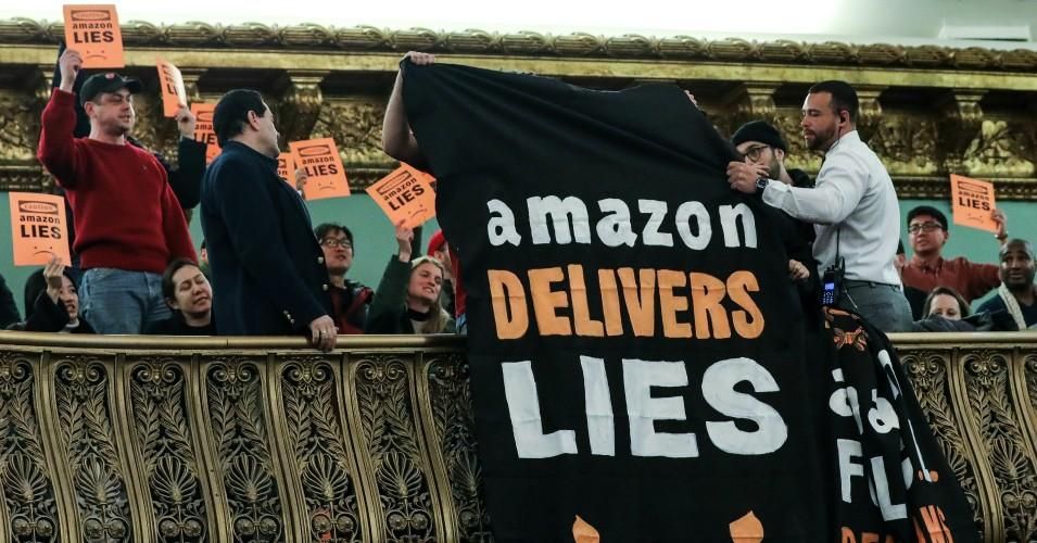 Protestors unfurl anti-Amazon banners from the balcony of a hearing room during a New York City Council Finance Committee on January 30, 2019. 
