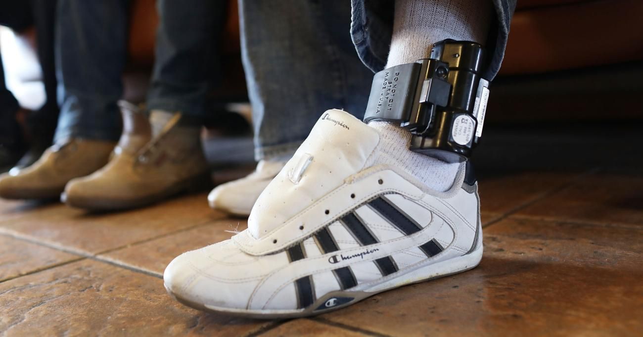 A father wears an ankle bracelet as he is cared for in an Annunciation House facility after being reunited with his son on July 25, 2018 in El Paso, Texas