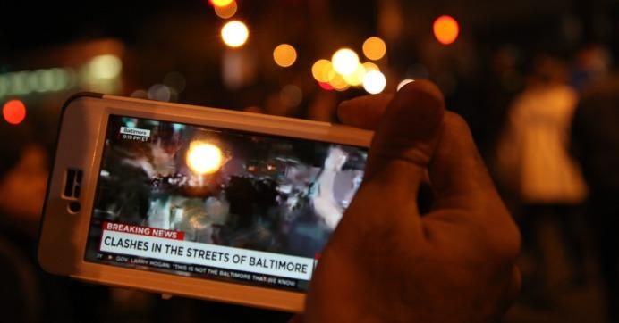 A cell phone shows an image of police brutality protests in Baltimore. (Photo: Arash Azizzada/flickr/cc)