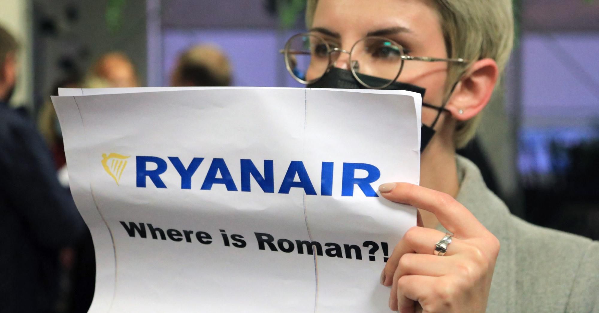A woman stands with a poster reading 'Where is Roman (Protasevich)?!' in the arrival area as passengers disembark from a Ryanair passenger plane from Athens, Greece, that was intercepted and diverted to Minsk on the same day by Belarus authoritie.