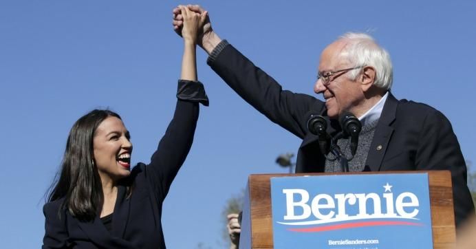 Democratic presidential candidate Sen. Bernie Sanders (D-Vt.) holds hands with Rep. Alexandria Ocasio-Cortez (D-N.Y.) during his speech at a campaign rally in Queensbridge Park on October 19, 2019 in the Queens borough of New York City