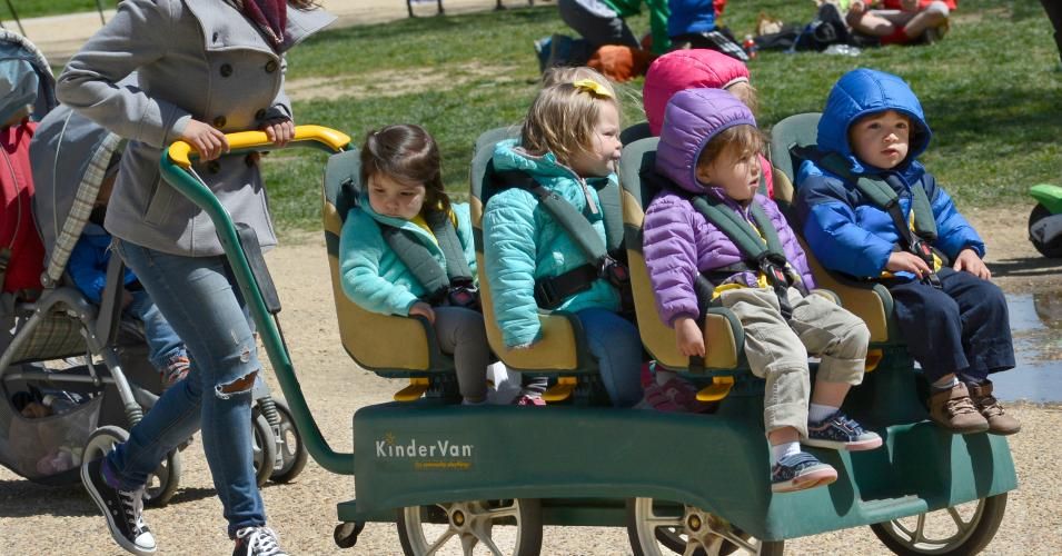 A daycare center employee pushes a KinderVan filled with preschool children on an outing along the National Mall in Washington, D.C. (Photo: Robert Alexander/Getty Images)