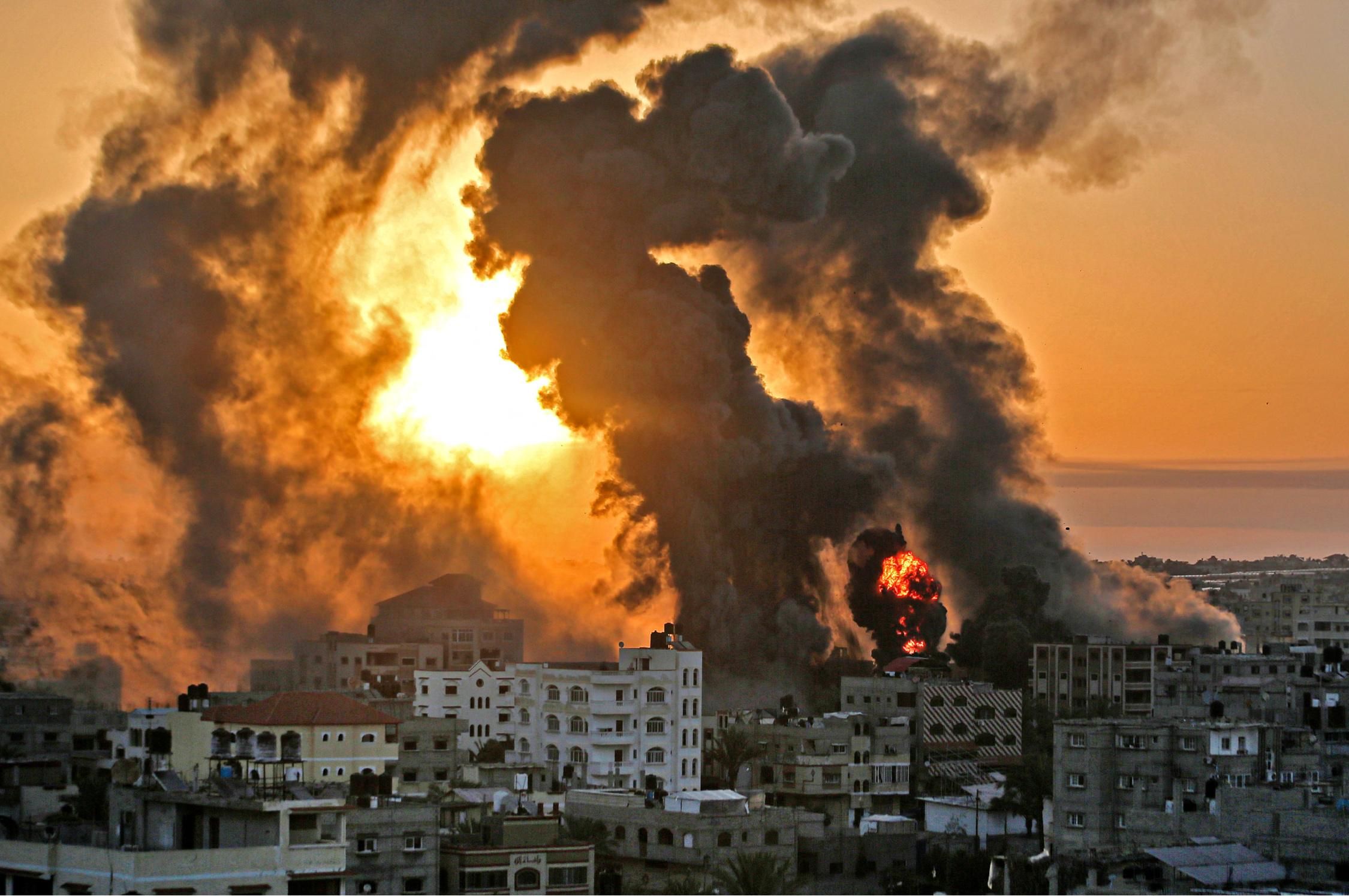A fire rages at sunrise in Khan Yunish following an Israeli airstrike on the southern Gaza Strip on May 12, 2021.
