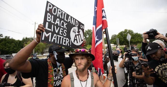 Anti-racist and anti-facist protesters organized by F.L.O.W.E.R, a frontline organization based in Atlanta to combat racism, face off against far right militias and white pride organizations near Stone Mountain Park in downtown Stone Mountain, Georgia on August 15, 2020.