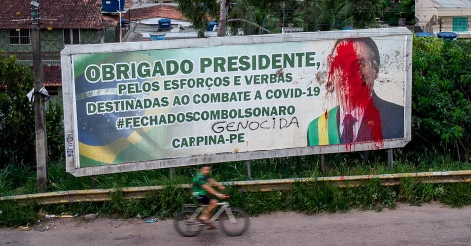 A billboard with the image of Brazilian President Jair Bolsonaro is seen vandalized with red paint and feces as a protest of his governmental management of the coronavirus pandemic, in Carpina, Pernambuco state, Brazil, on March 27, 2021. (Photo: Leo Malafaia/AFP via Getty Images) 