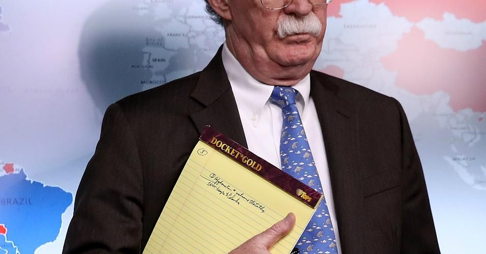 With handwritten notes on a legal pad, part of which looks like it reads "5,000 troops to Colombia," National Security Advisor John Bolton listens to questions from reporters during a press briefing at the White House January 28, 2019 in Washington, DC.