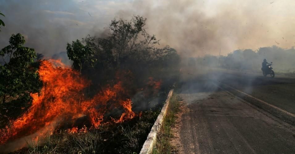 A fire burns along a highway in a deforested section of the Amazon basin on November 23, 2014 in Ze Doca, Brazil. 