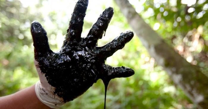 A hand covered in crude from one of the hundreds of open toxic pits Chevron (formerly Texaco) abandoned in the Ecuadorian Amazon rainforest near Lago Agrio. (Photo: Caroline Bennett, Rainforest Action Network/flickr/cc)