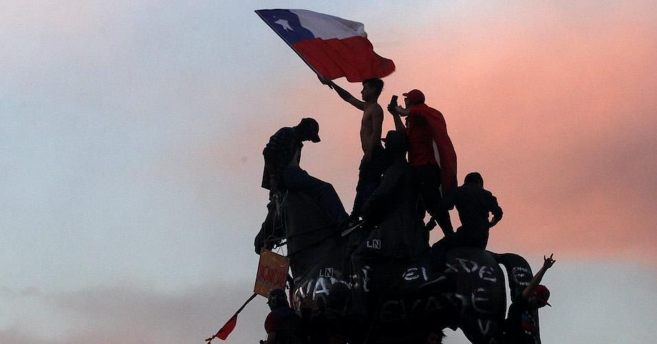 Protesters wave a Chilean flag during the eighth day of protests against President Sebastian Piñera's government on October 25, 2019 in Santiago, Chile. 