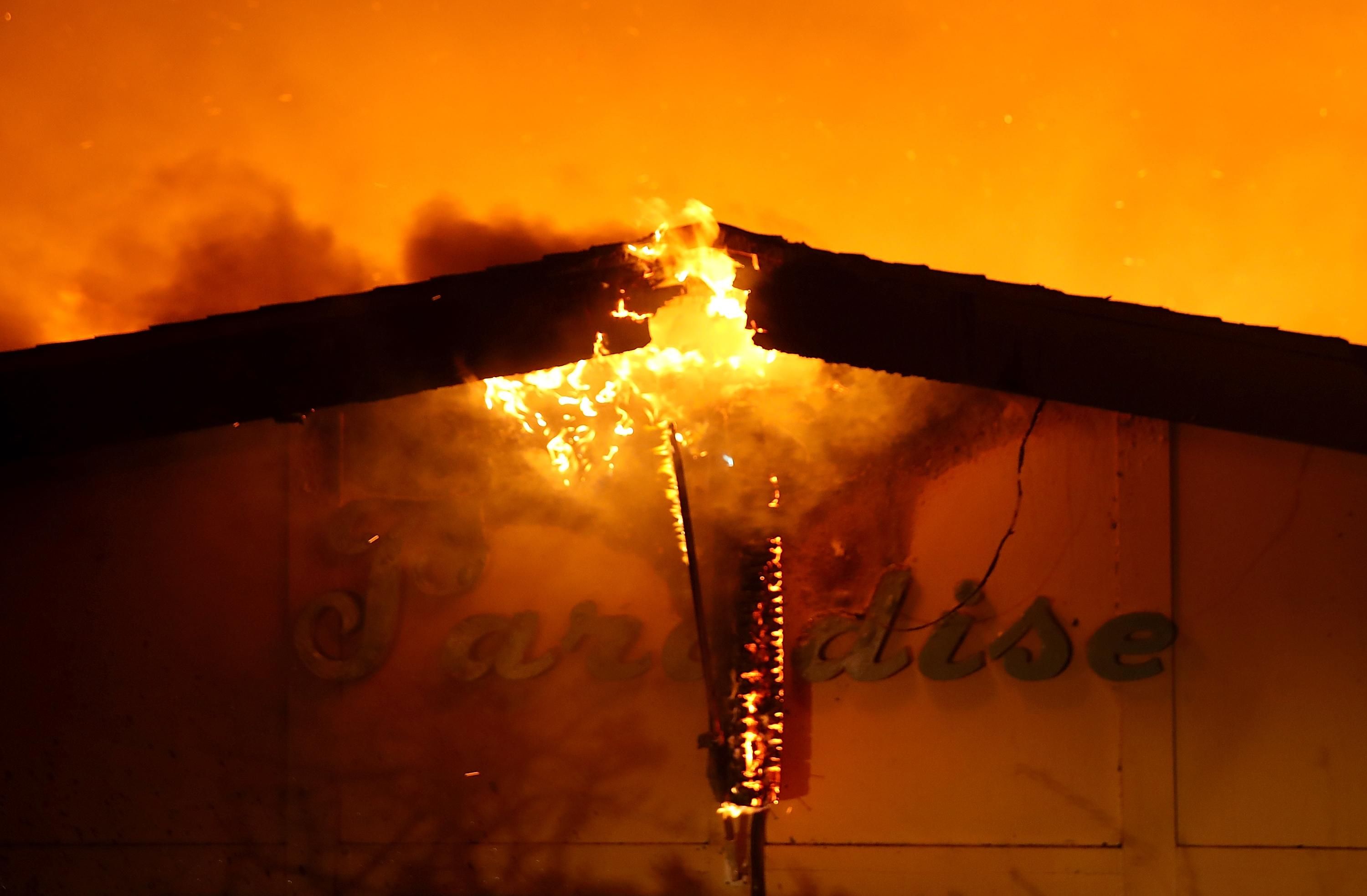A sign is posted on the Paradise Skilled Nursing center as it is consumed by flames from the Camp Fire on November 8, 2018 in Paradise, California.