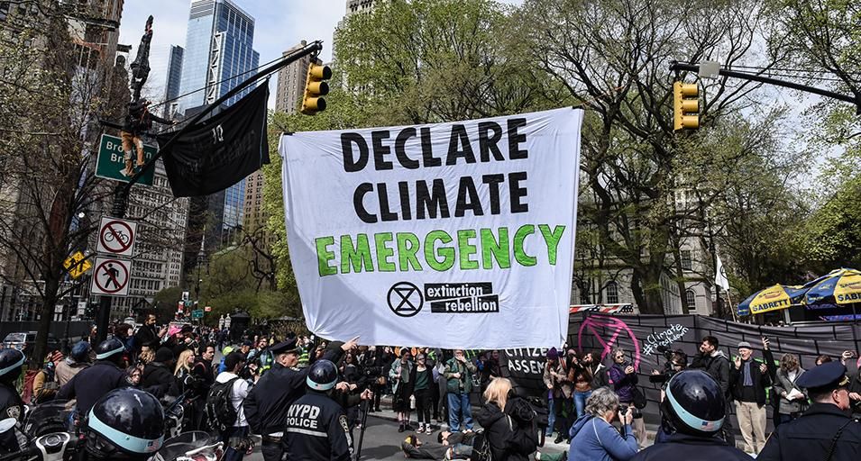 A banner is hung across a roadway while people participate in direct action with Extinction Rebellion on April 17, 2019 in New York City. The activists are demanding governments to declare a climate emergency. 