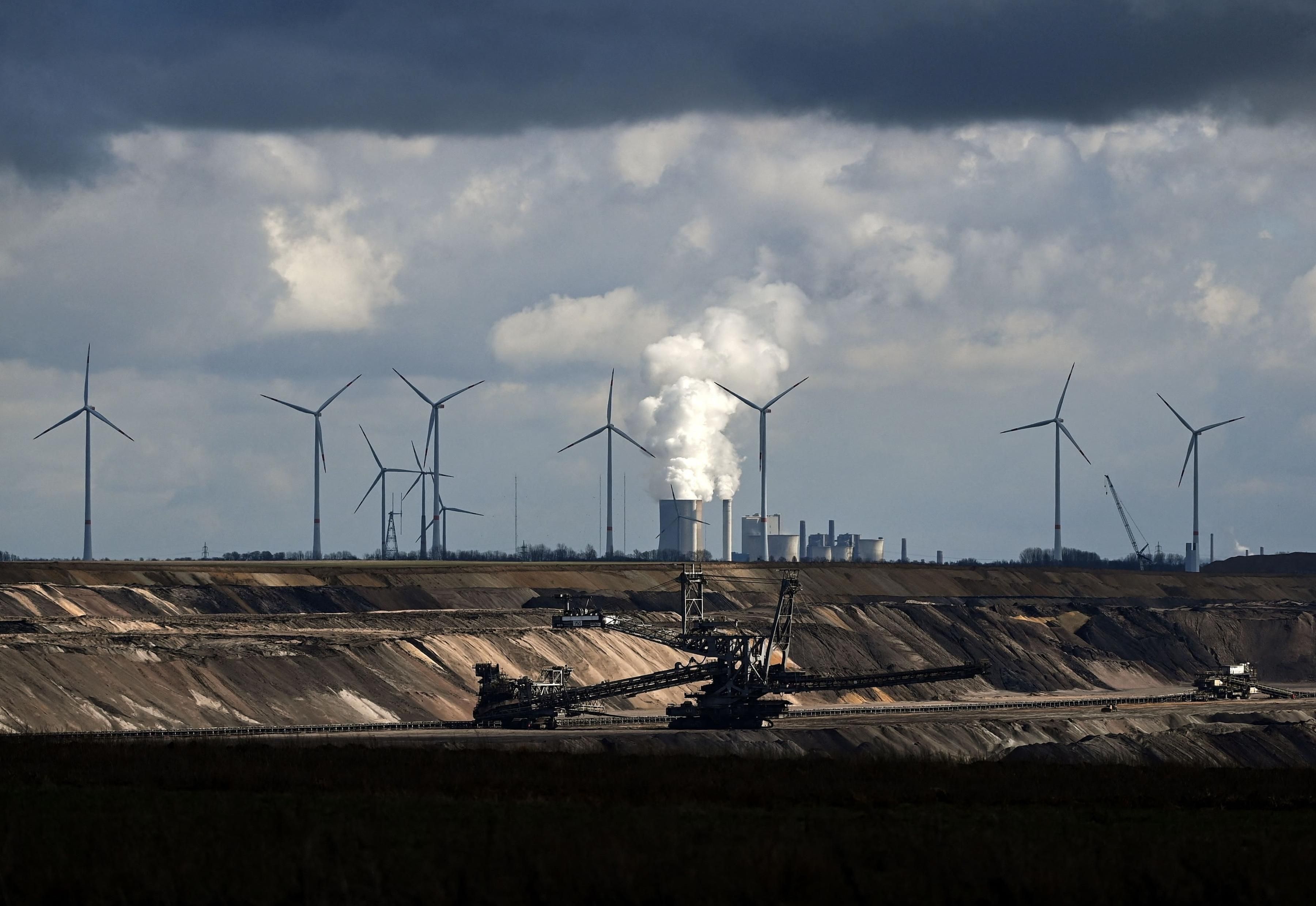 In Garzweiler, Germany, wind turbines are seen near an open-cast mining operation and a coal-fired power plant run by German energy giant RWE on March 15, 2021. (Photo: Ina Fassbender/AFP via Getty Images)