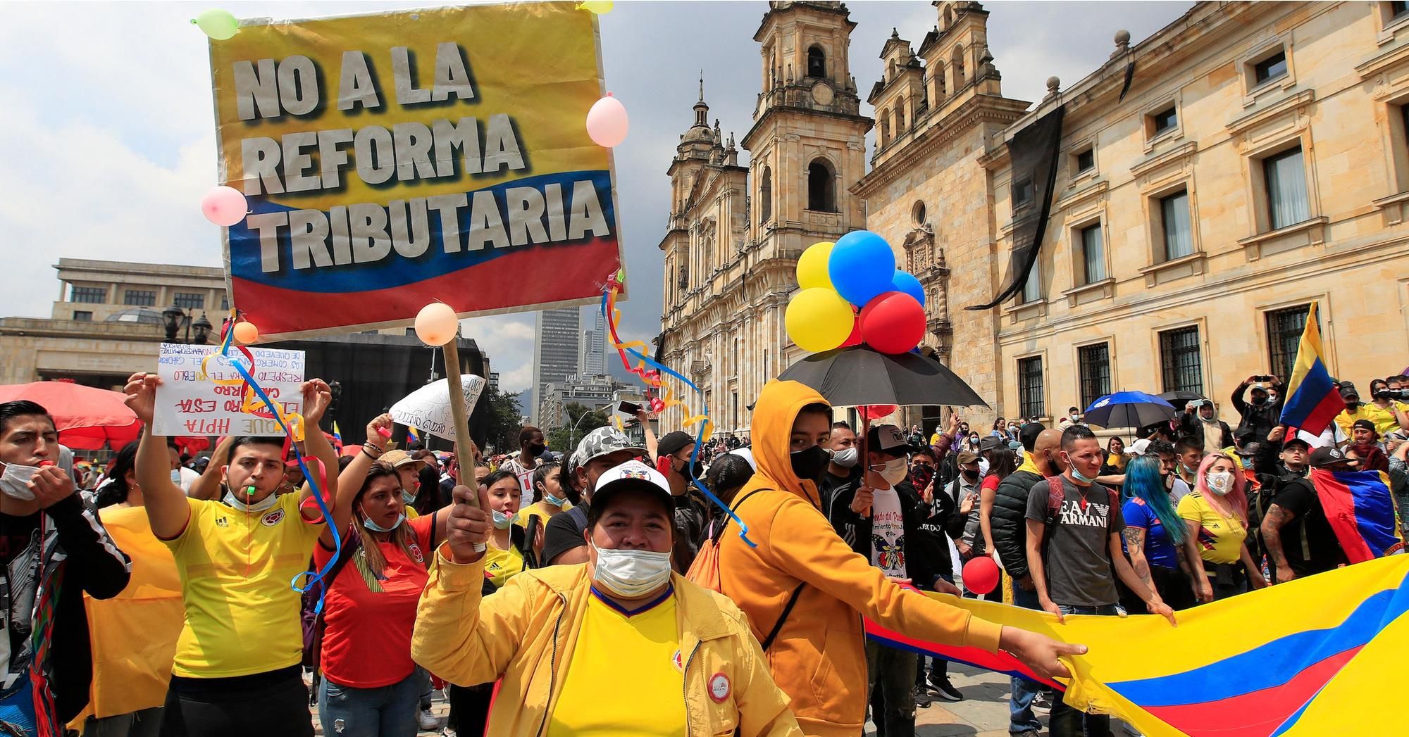 Colombian demonstrators—one holding a sign saying "No to Tax Reform"—gathered in Bogotá's Bolívar Square on May 1, 2021 to protest panned tax reform and other issues. (Photo: Daniel Munoz/AFP via Getty Images)