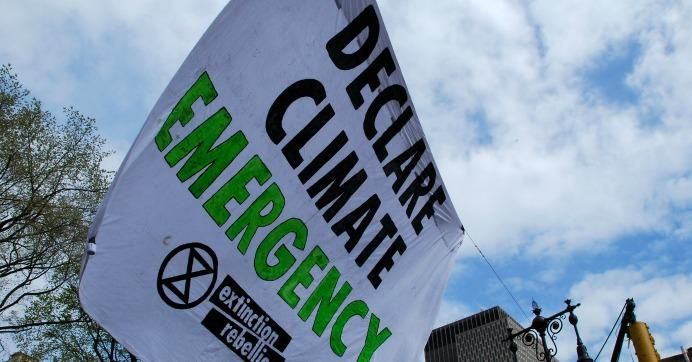 Sign reads: Declare Climate Emergency