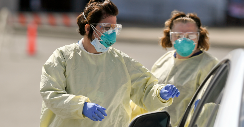 Certified registered nurses Kimberly Scheider, left, and Debbie Jessell, right, walk up to a patient's car before starting a Covid-19 test at Penn State Health St. Joseph on March 27, 2020. (Photo: Ben Hasty/MediaNews Group/Reading Eagle via Getty Images)