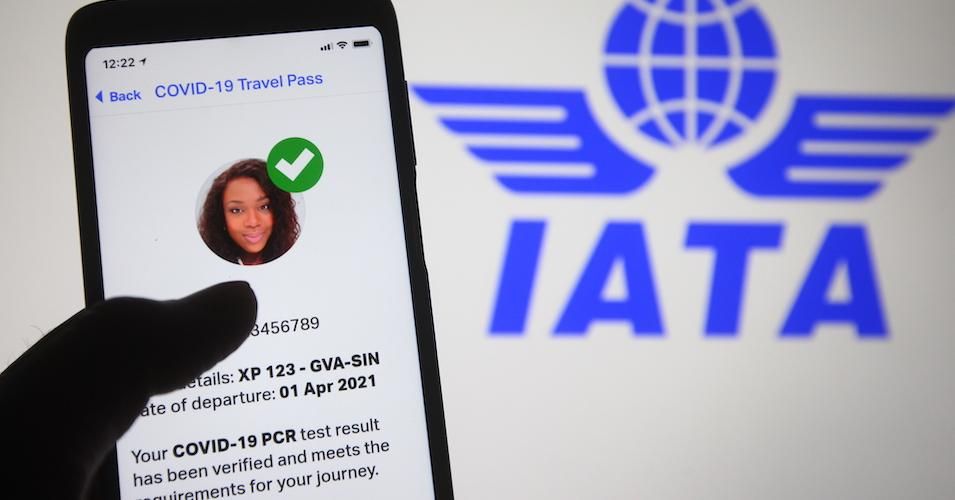 In this photo illustration, a message saying Covid-19 PCR test result has been verified from the Travel Pass app mobile application by IATA (International Air Transport Association) seen displayed on a smartphone screen in front of IATA logo. 