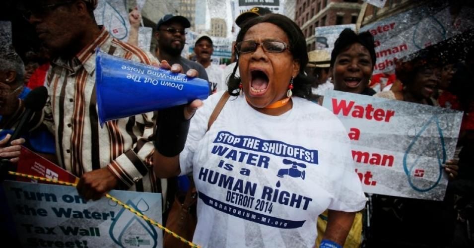 A demonstrator wears a t-shirt declaring "Water is a human right"