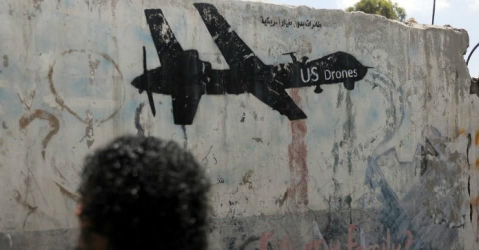 A man walks by U.S. drone graffiti painted on a wall during a campaign against drones in Yemen on May 31, 2018 in Sana'a, Yemen.