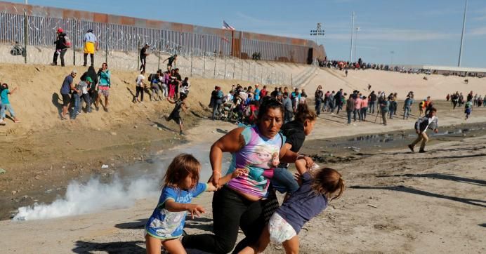 A migrant family, part of a caravan of thousands traveling from Central America en route to the United States, run away from tear gas in front of the border wall between the U.S and Mexico in Tijuana, Mexico November 25, 2018. 