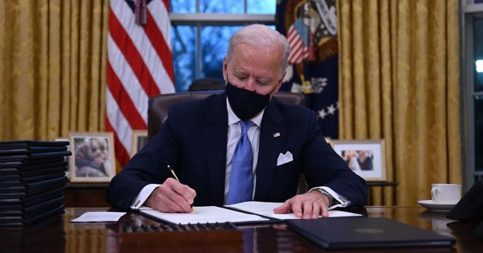 Newly-inaugurated President Joe Biden signs one of a slate of executive orders during the early hours of his administration on January 20, 2021. (Photo: Jim Watson/AFP via Getty Images) 
