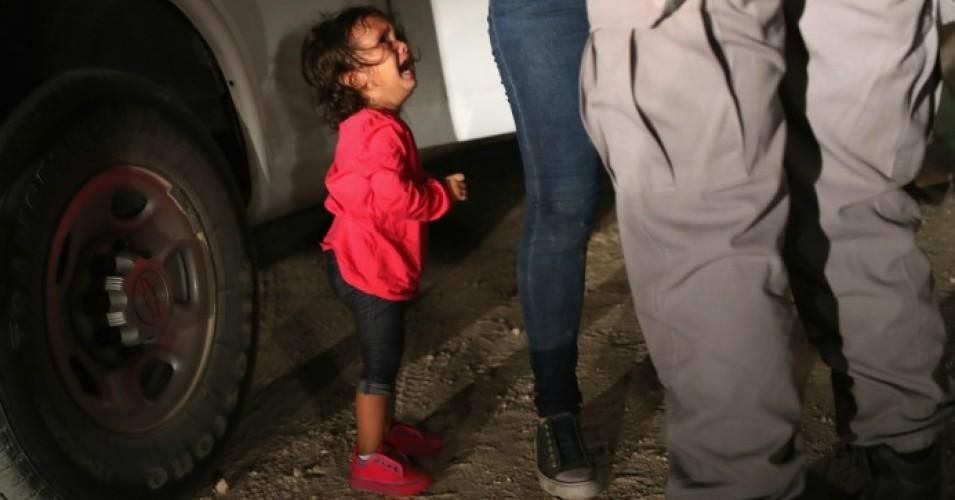 A two-year-old Honduran asylum seeker cries as her mother is searched and detained near the U.S.-Mexico border on June 12, 2018 in McAllen, Texas. The asylum seekers had rafted across the Rio Grande from Mexico and were detained by U.S. Border Patrol agents before being sent to a processing center for possible separation. (Photo: John Moore/Getty Images)