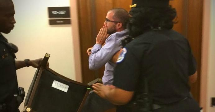 Capitol Hill police carry one of the five protesters from the Senate Committee on Energy and Natural Resources hearing on President Donald Trump's FERC nominees on Thursday. (Photo courtesy of Beyond Extreme Energy)