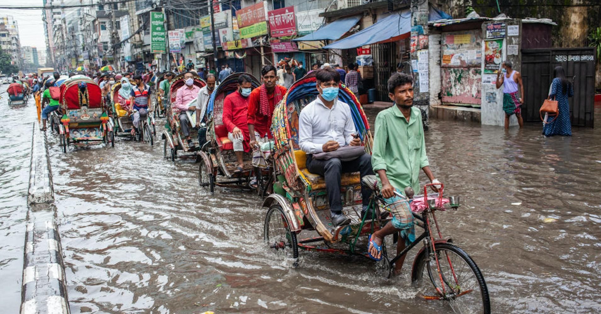 Commuters in Dhaka, Bangladesh contend with floodwaters following heavy rains on October 12, 2020. (Photo: Nayan Kar/SOPA Images/LightRocket/Getty Images)