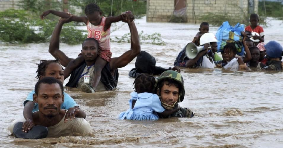 Members of the Jordanian battalion of the United Nations Stabilization Mission in Haiti (MINUSTAH) carry children through flood waters in Port au Prince, Haiti after a rescue from an orphanage destroyed by Hurricane Ike in 2008. (Photo: UN Photo/Marco Dormino)