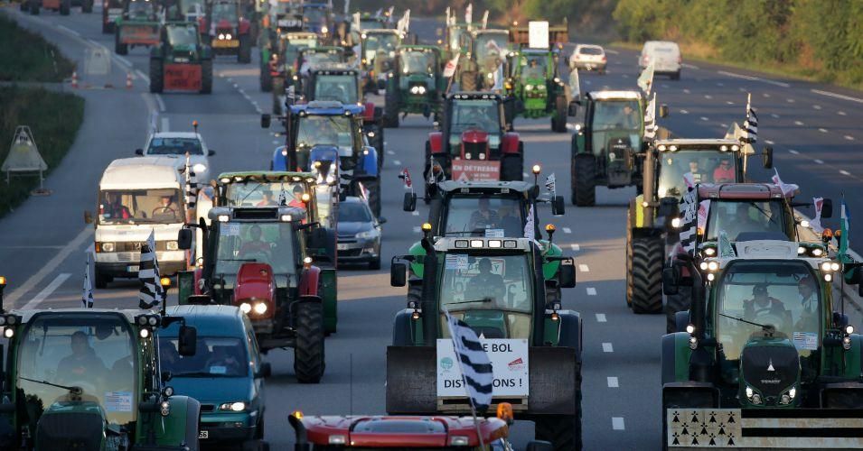 French farmers painted political messages of protest on their tractors before rolling into Paris on Thursday.