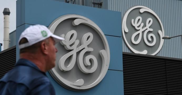 A General Electric employee walks past a logo, as French Economy and Finance Minister Bruno Le Maire take part to a meeting with managers and unions at the GE headquarters in Belfort, eastern France, on June 3, 2019. 