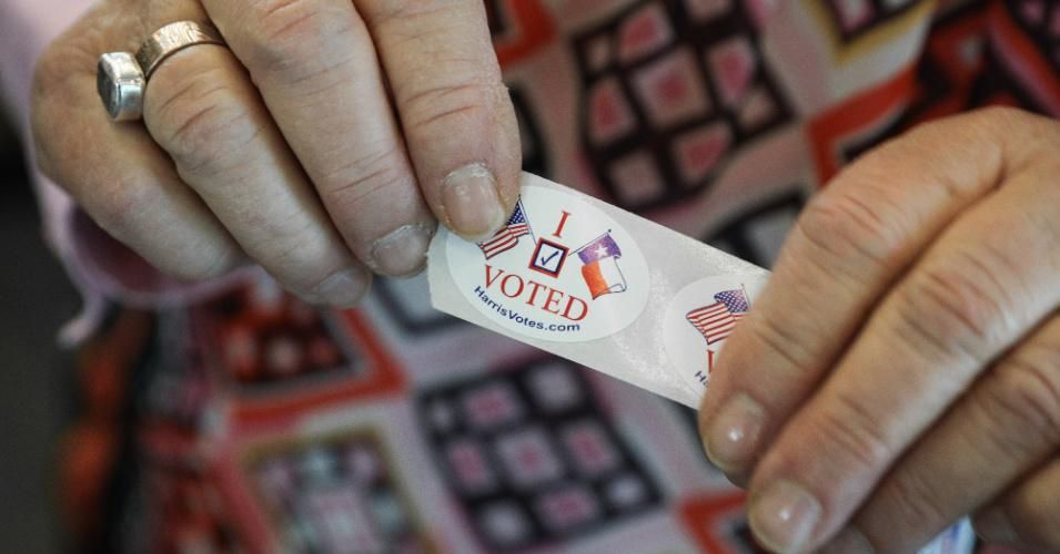 A woman hands out "I voted" stickers to voters at the Rummel Creek Elementary polling place on November 6, 2018 in Houston, Texas. (Photo: Loren Elliott/Getty Images)