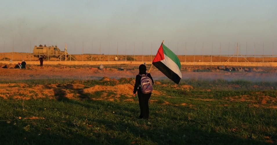 A Palestinian girl seen with a flag during the clashes on the Gaza-Israel wall east of Khan Yunis on Jan. 4, 2019. 
