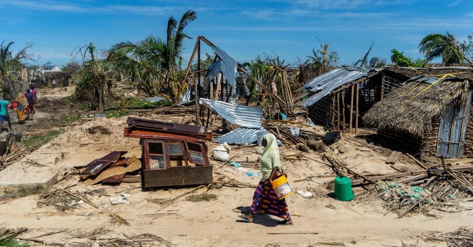 A woman walks past destroyed houses on May 13, 2019, on her way to an aid distribution center in the coastal village of Guludo on Ibo Island, in Mozambique's Cabo Delgado province, in the aftermath of a devastating cyclone. (Photo: Zinyange Auntony/AFP via Getty Images)