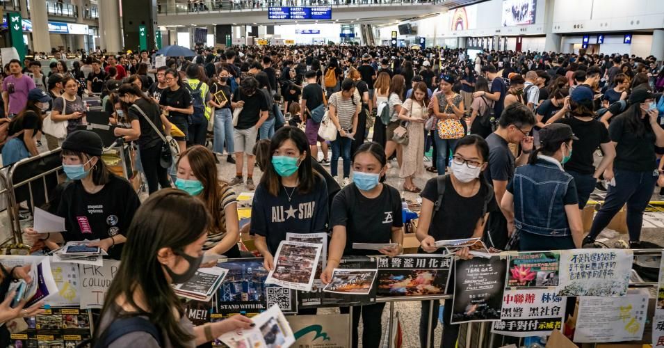  Pro-democracy protesters hand out leaflets at the arrival hall of the Hong Kong International Airport 