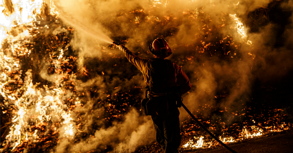 Firefighters sprays water on a back fire while battling the spread of the Maria Fire as it moves quickly towards Santa Paula, California, on Nov. 1, 2019.