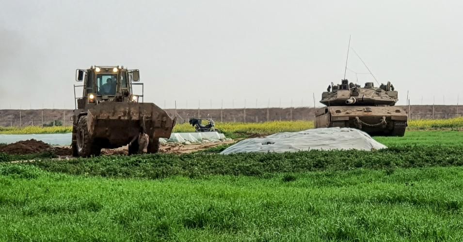 an Israeli bulldozer carrying a body of a Palestinian