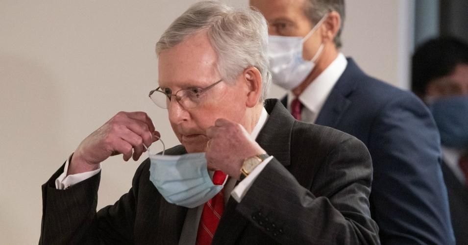 Senate Majority Leader Mitch McConnell (R-Ky.) removes a mask he is wearing to protect himself and others from Covid-19 as he arrives to speak to the media following the weekly Republican policy luncheon on Capitol Hill in Washington, D.C., May 5, 2020. 