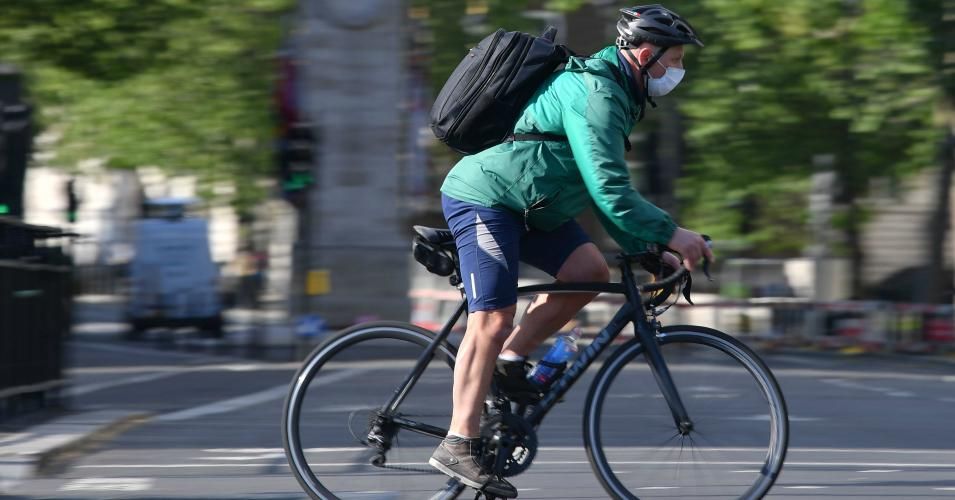 Cyclists travel in central London on May 12, 2020, during the novel coronavirus pandemic. The British government on Monday published what it said was a "cautious roadmap" to ease the seven-week coronavirus lockdown in England, notably recommending people wear facemasks in some public settings.