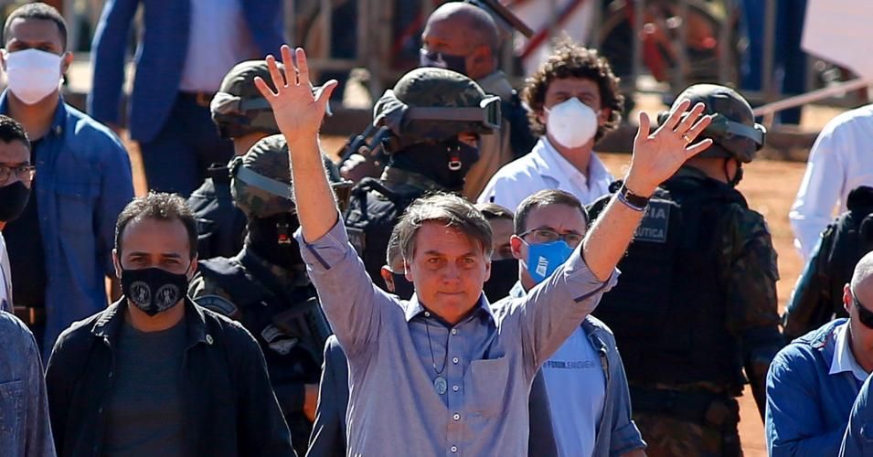 Brazilian President Jair Bolsonaro (C) waves to supporters during the inauguration of a field hospital in Aguas Lindas, in the State of Goiais, Brazil, on June 5, 2020 amid the Covid-19 pandemic.
