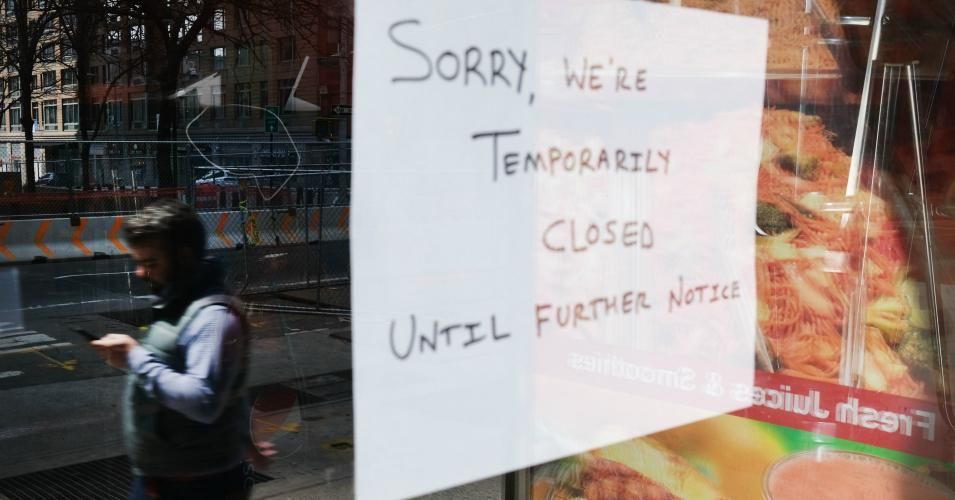 A closed sign is displayed in the window of a business in a nearly deserted lower Manhattan on April 17, 2020.