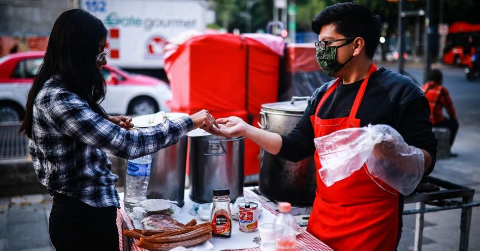 Alex Hernandez prepares sells a "torta de tamal" in his tamales stand at Baja California Avenue on April 17, 2020 in Mexico City, Mexico. 