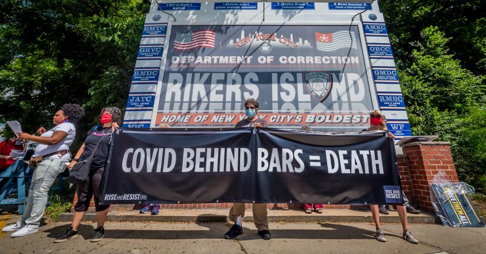 Protesters hold a banner reading COVID BEHIND BARS = DEATH at a rally on Rikers Island in New York City on June 19, 2020. (Photo: Erik McGregor/LightRocket via Getty Images)
