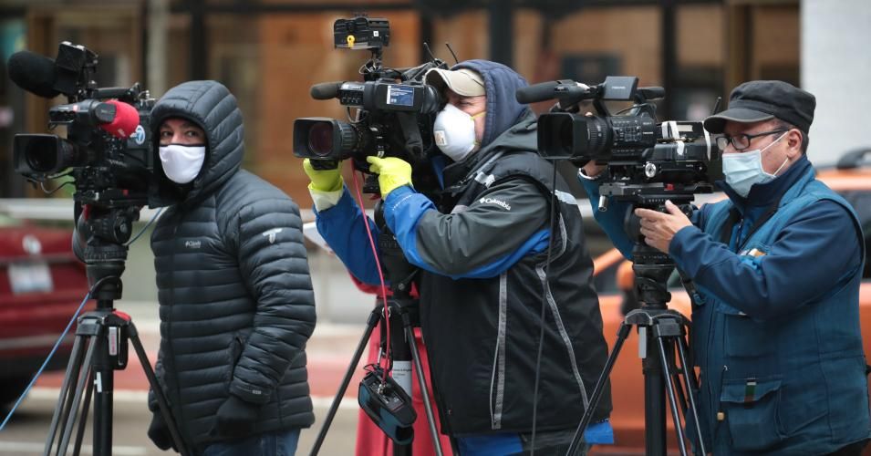 Journalists wearing masks document a protest in Chicago where demonstrators were calling on the Illinois governor to suspend rent and mortgage payments to help those who have lost their income due to the coronavirus on April 30, 2020. 