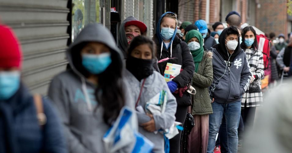 Citizens wearing protective masks form lines to receive free food from a food pantry run by the Council of Peoples Organization on May 8, 2020 in the Midwood neighborhood of Brooklyn, New York. (Photo: Andrew Lichtenstein/Corbis via Getty Images)