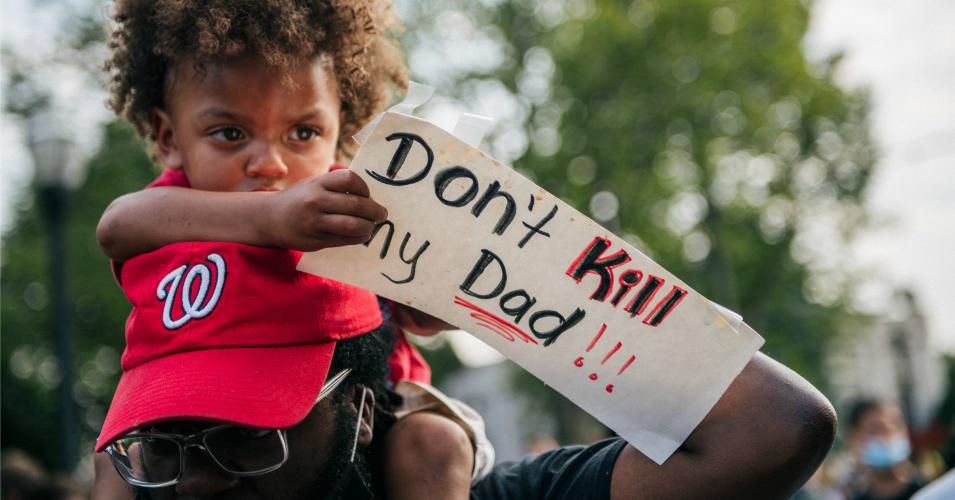 A boy sits on his father's shoulders while holding a sign on August 24, 2020 in Kenosha, Wisconsin. (Photo: Brandon Bell/Getty Images)