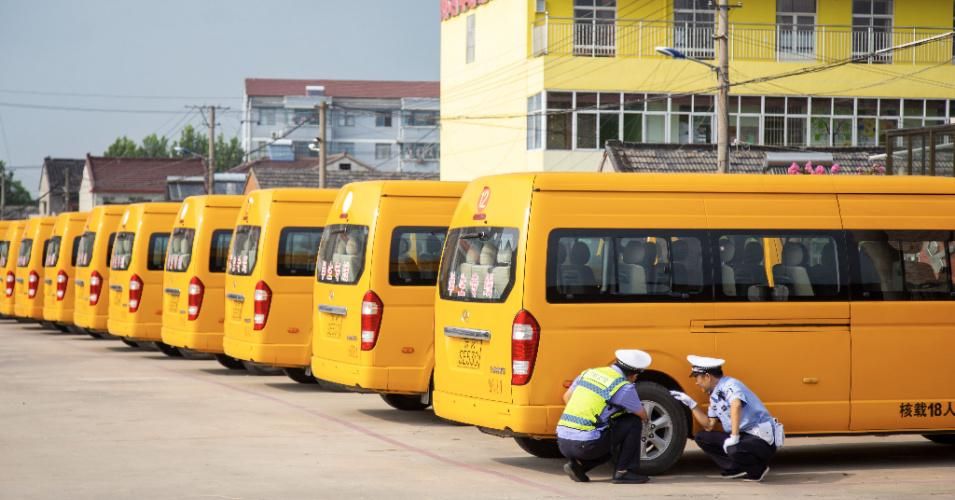 Traffic police check the tires of electric school buses in Yangzhou, Jiangsu Province, China, on August 25, 2020. (Photo: Costfoto/Barcroft Media via Getty Images)